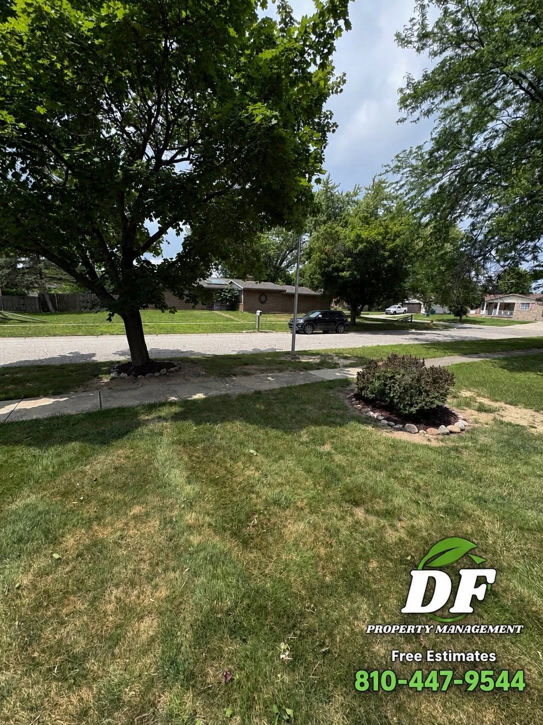 Freshly mowed front yard with clean mower stripes and a tidy planting bed, serviced by DF Property Management in Genesee County